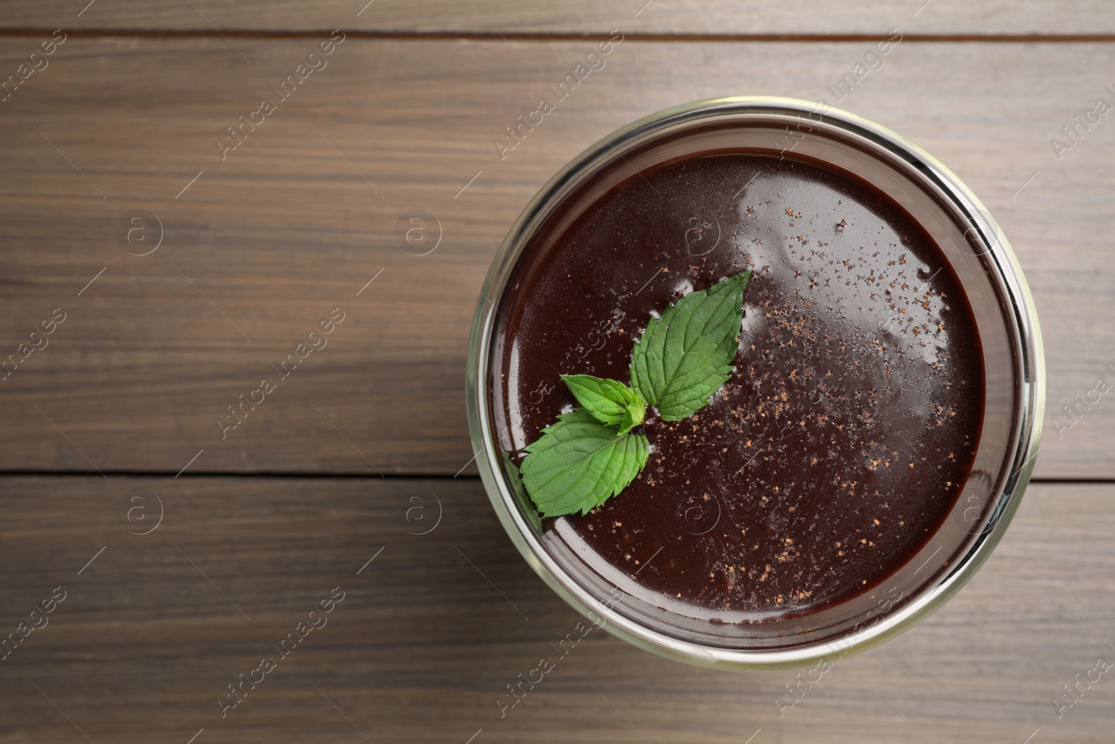 Photo of Glass of delicious hot chocolate and fresh mint on wooden table, top view. Space for text