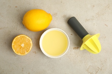 Photo of Freshly squeezed lemon juice on light grey table, flat lay