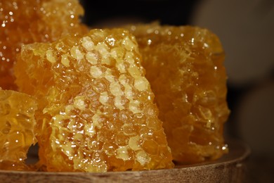 Photo of Natural honeycombs on wooden board, closeup. Space for text