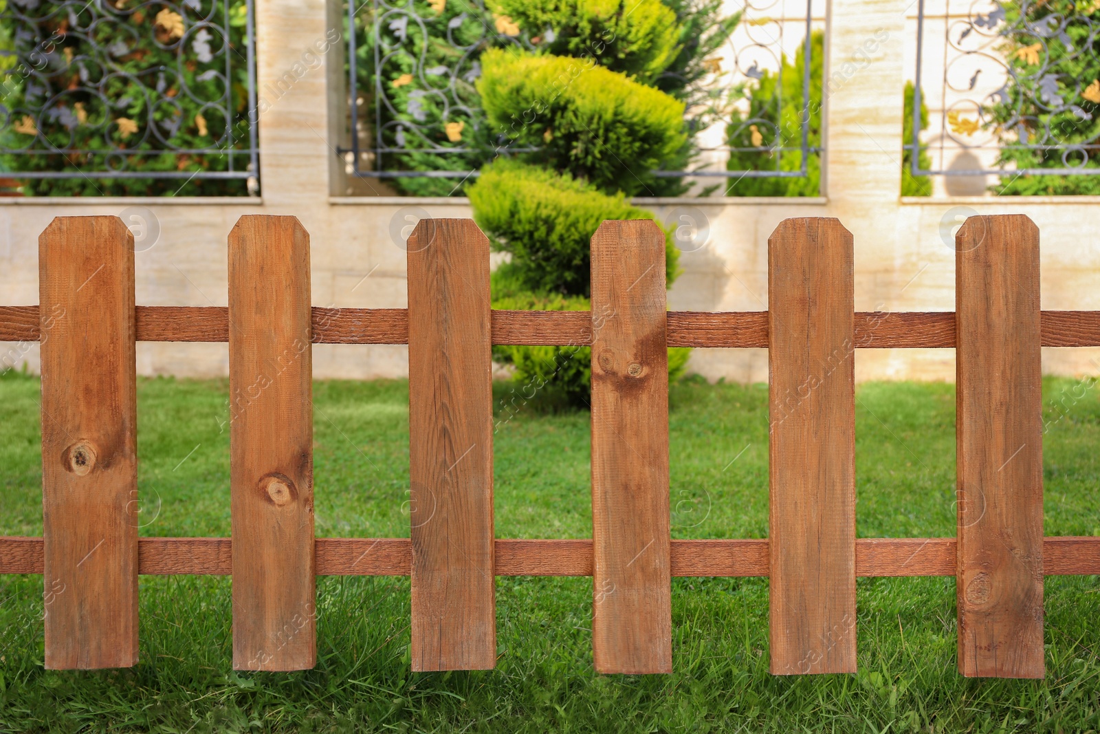 Photo of Small wooden fence near green bush in garden