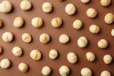 Flat lay composition with shelled organic Macadamia nuts on color background