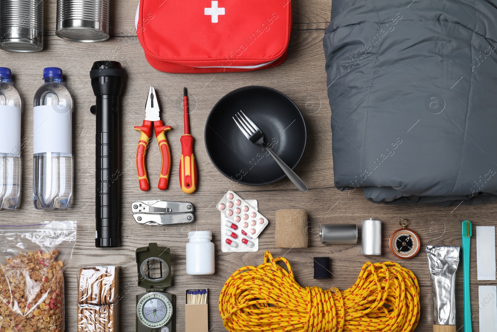 Photo of Disaster supply kit for earthquake on wooden table, flat lay