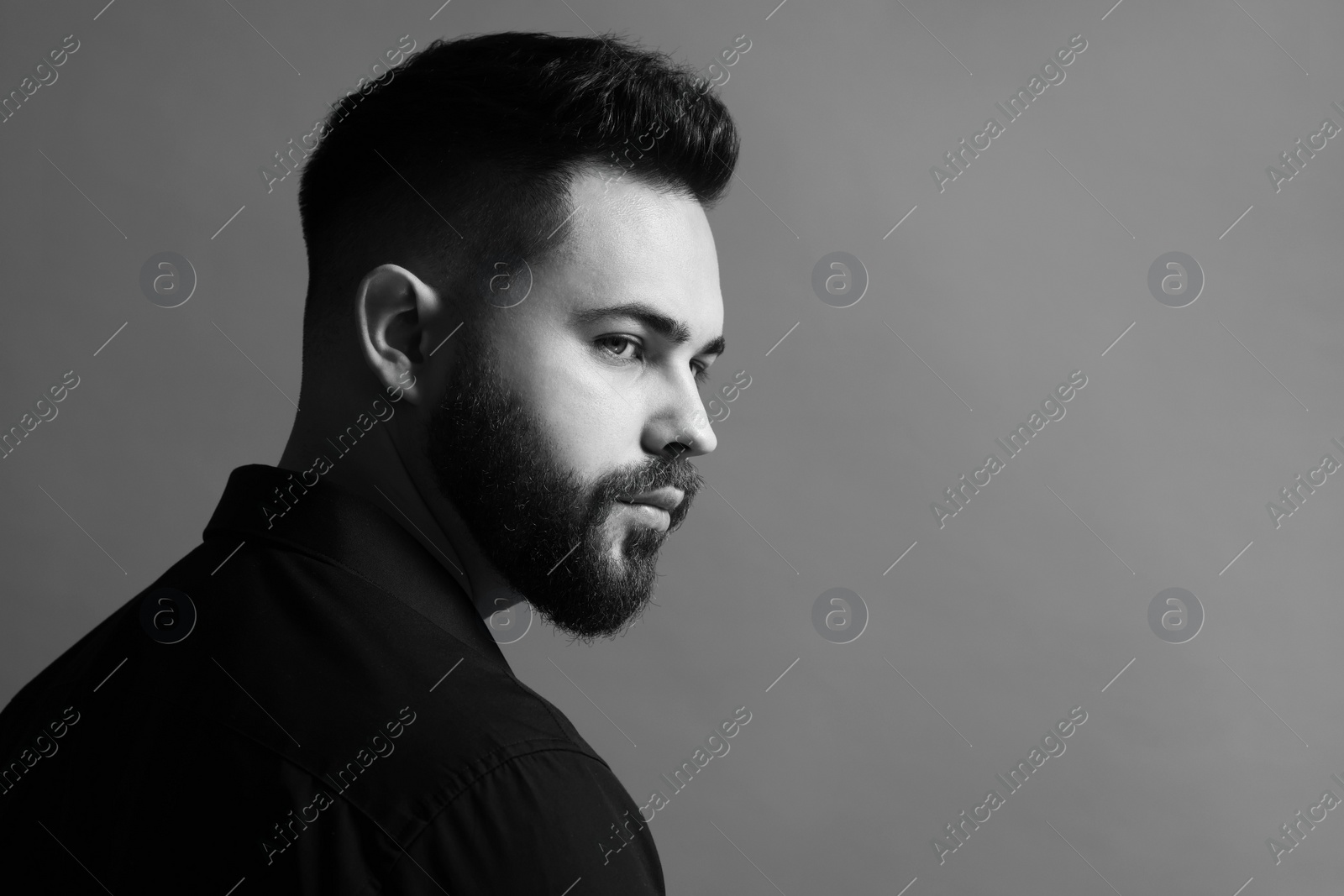 Photo of Portrait of handsome bearded man on grey background, space for text. Black and white effect