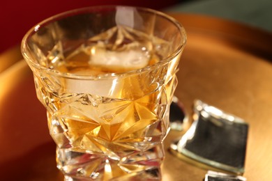 Photo of Glass of alcohol drink on golden tray, closeup. Space for text