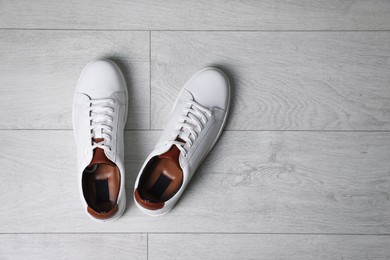 Photo of Pair of stylish sports shoes on white wooden floor, flat lay. Space for text