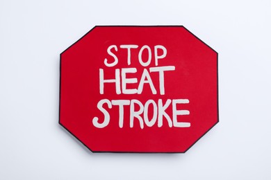 Photo of Sign with phrase Stop Heat Stroke on white background, top view