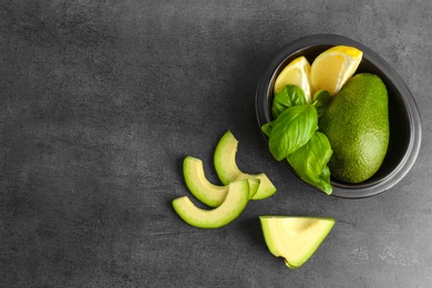 Photo of Flat lay composition with ripe avocados, lemon and basil on grey background