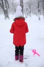 Cute little child outdoors on winter day, back view. Christmas vacation