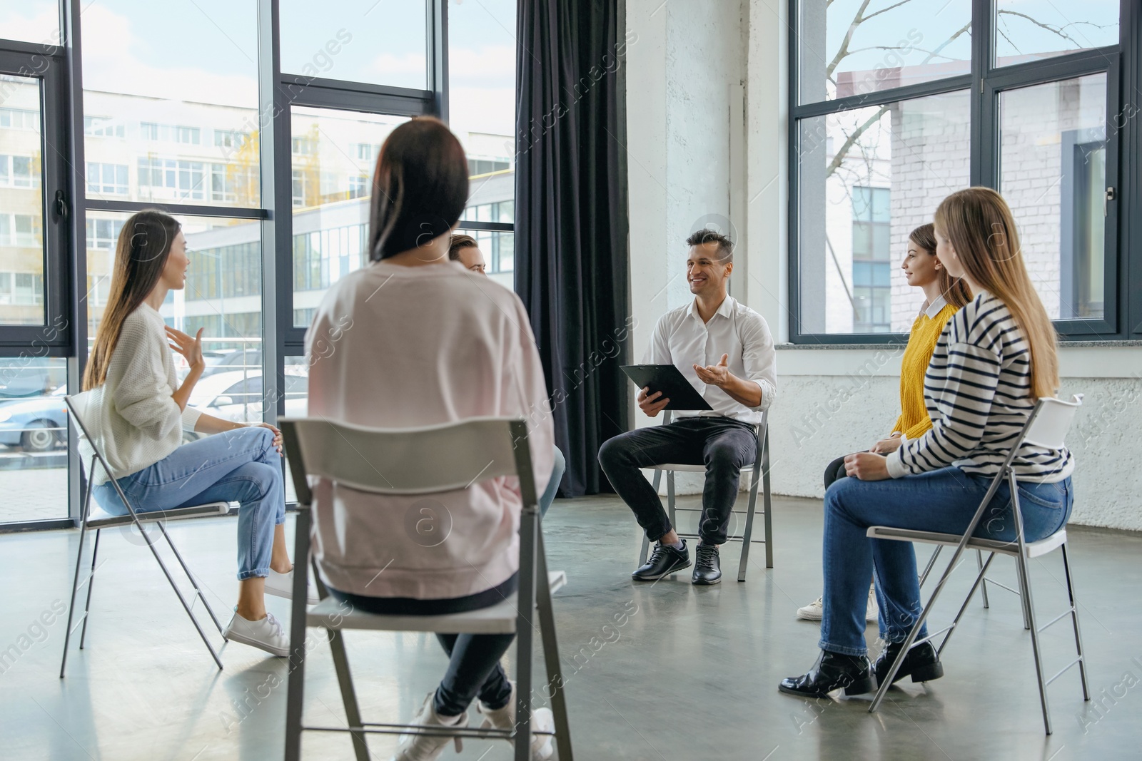 Photo of Psychotherapist working with patients in group therapy session indoors