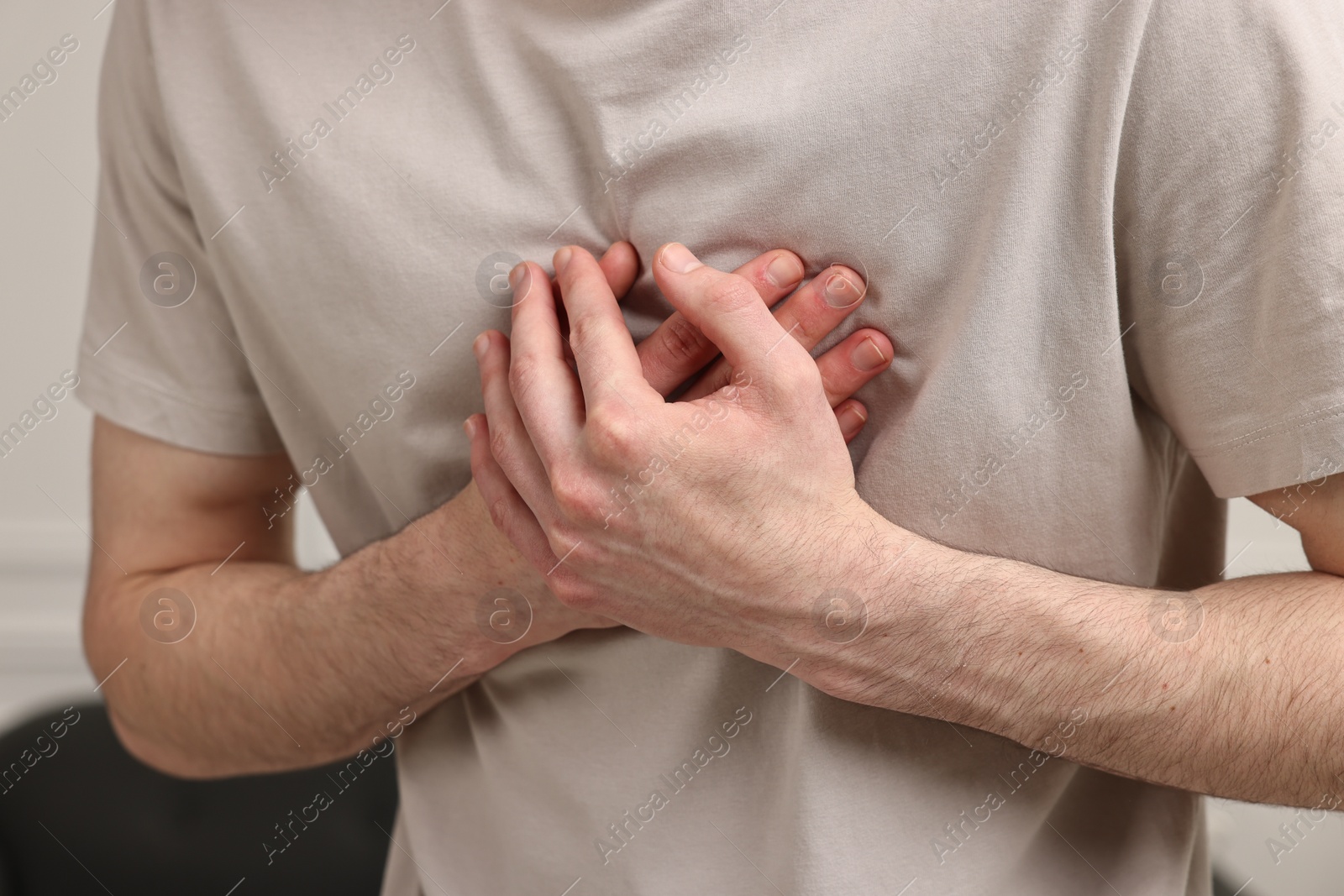 Photo of Man suffering from heart hurt at home, closeup