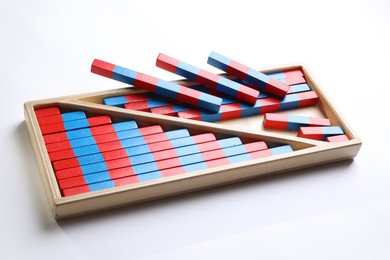 Photo of Wooden box with red and blue numerical sticks isolated on white. Montessori math toy