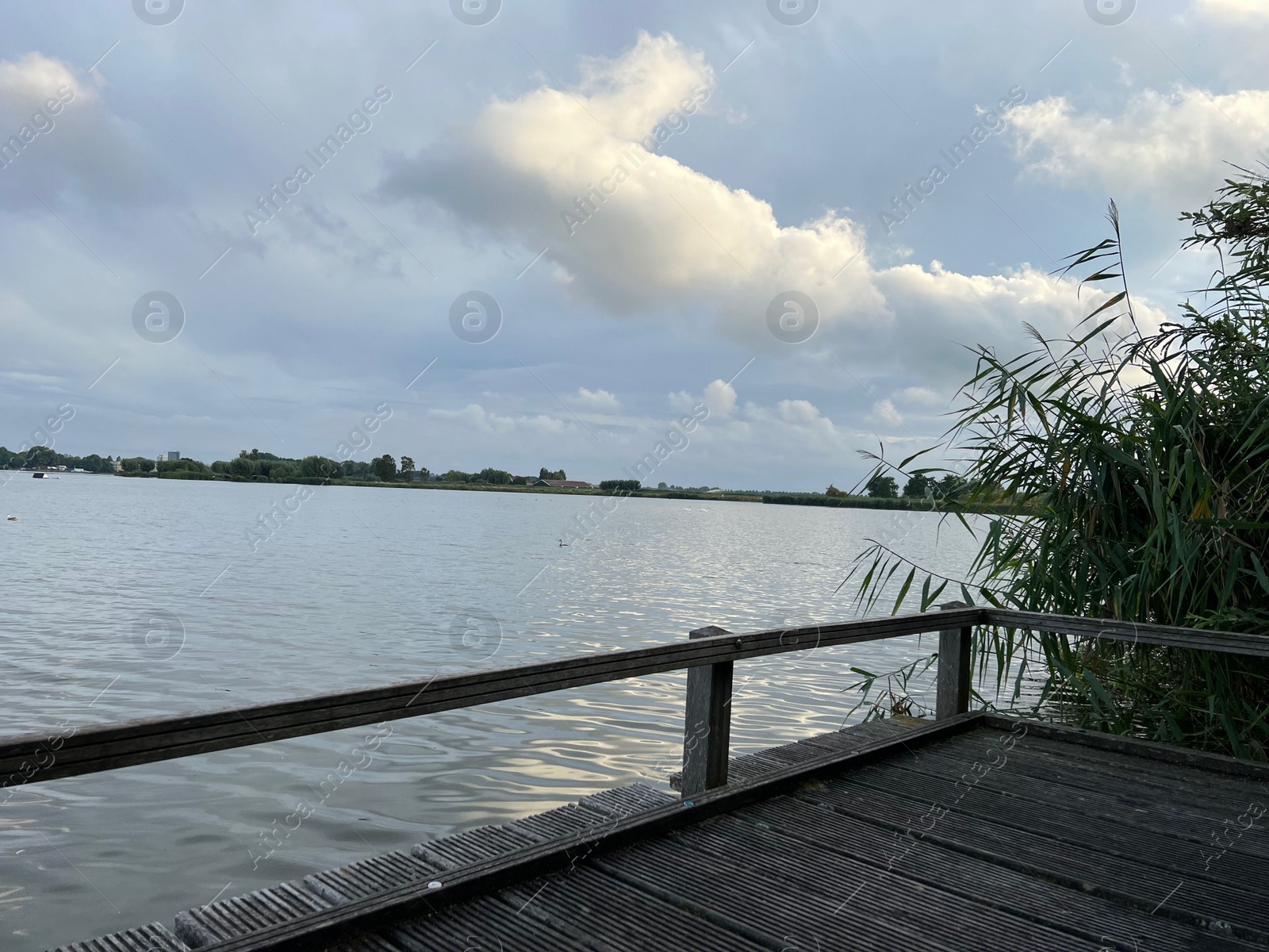 Photo of Picturesque view of river wooden pier and cloudy sky