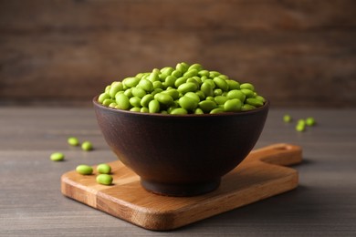 Photo of Bowl of delicious edamame beans on wooden table