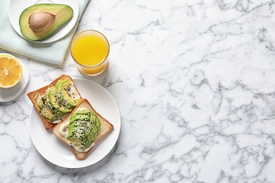 Photo of Flat lay composition with toast bread, avocado and glass of juice on marble background