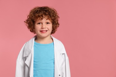 Photo of Portrait of little boy in medical uniform on pink background. Space for text