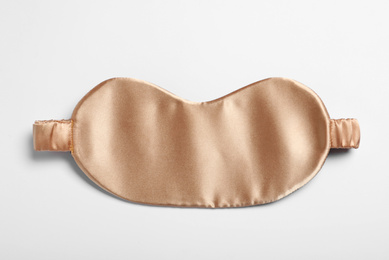 Photo of Beige sleeping mask isolated on white, top view. Bedtime accessory