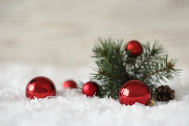 Beautiful Christmas balls and fir branch on snow