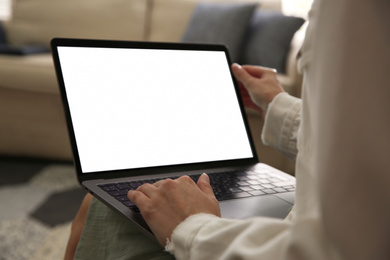 Woman using laptop at home, closeup. Space for design