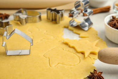 Cookie cutters and dough on table, closeup. Christmas biscuits