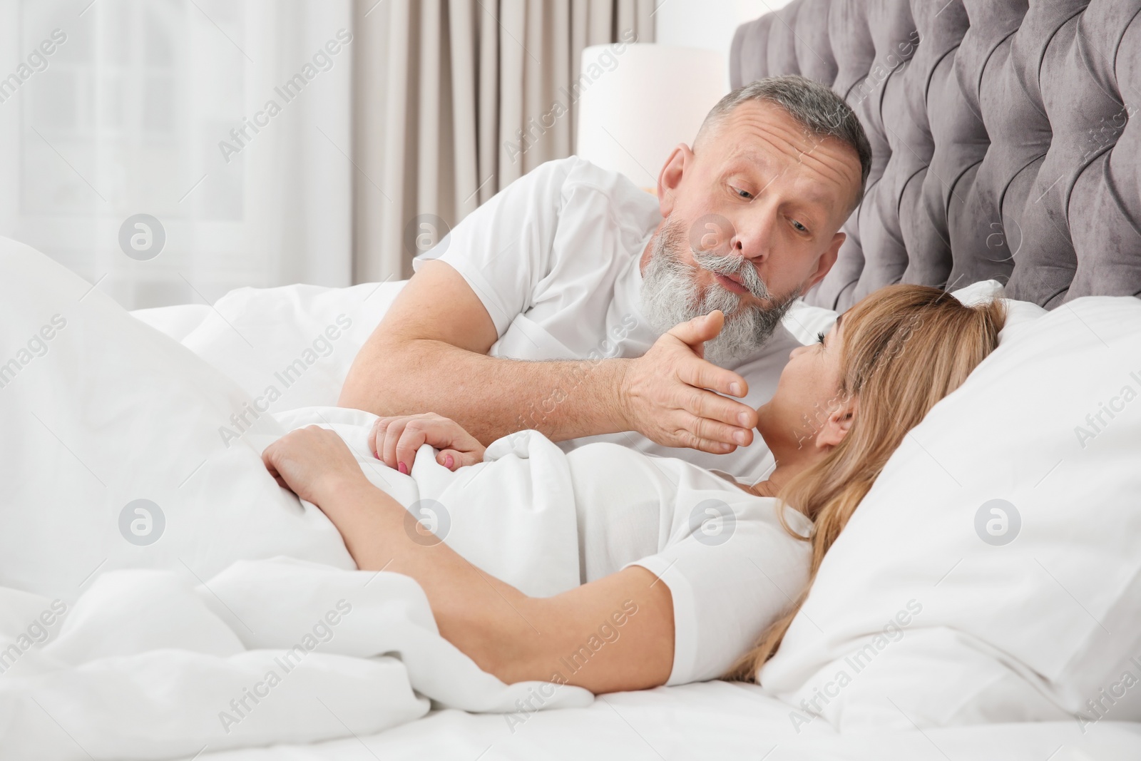 Photo of Mature couple together in bed at home