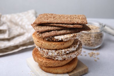 Photo of Stack of rye crispbreads, rice cakes and rusks on white table