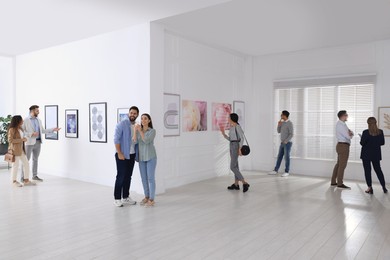 People viewing exposition in modern art gallery