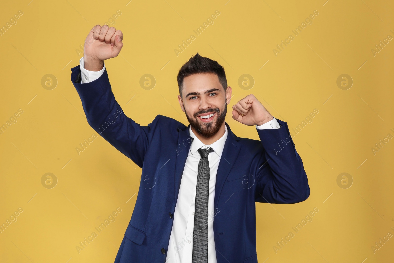 Photo of Happy young businessman celebrating victory on color background