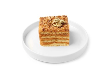 Photo of Piece of layered honey cake with walnuts on white background
