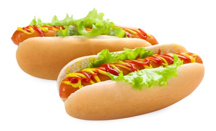 Photo of Tasty hot dogs with lettuce, ketchup and mustard isolated on white