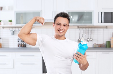 Photo of Man with bottle of protein shake in kitchen