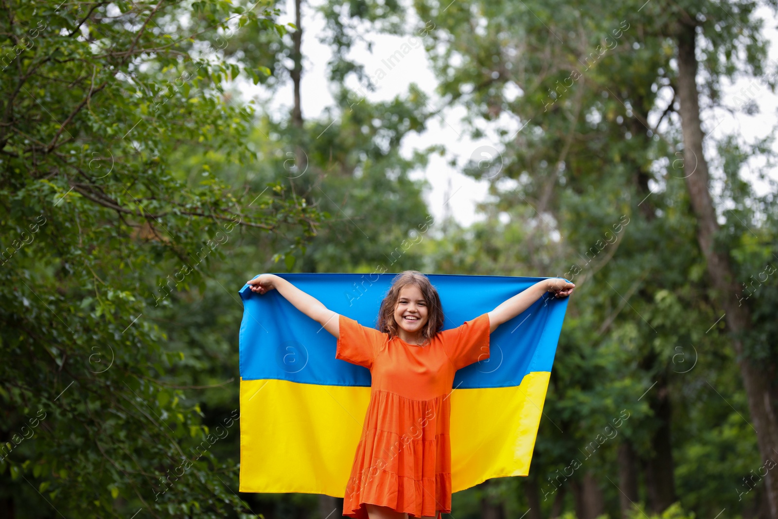 Photo of Teenage girl with flag of Ukraine outdoors