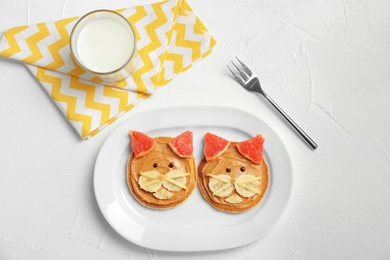 Flat lay composition with pancakes in form of cats on light background. Creative breakfast ideas for kids