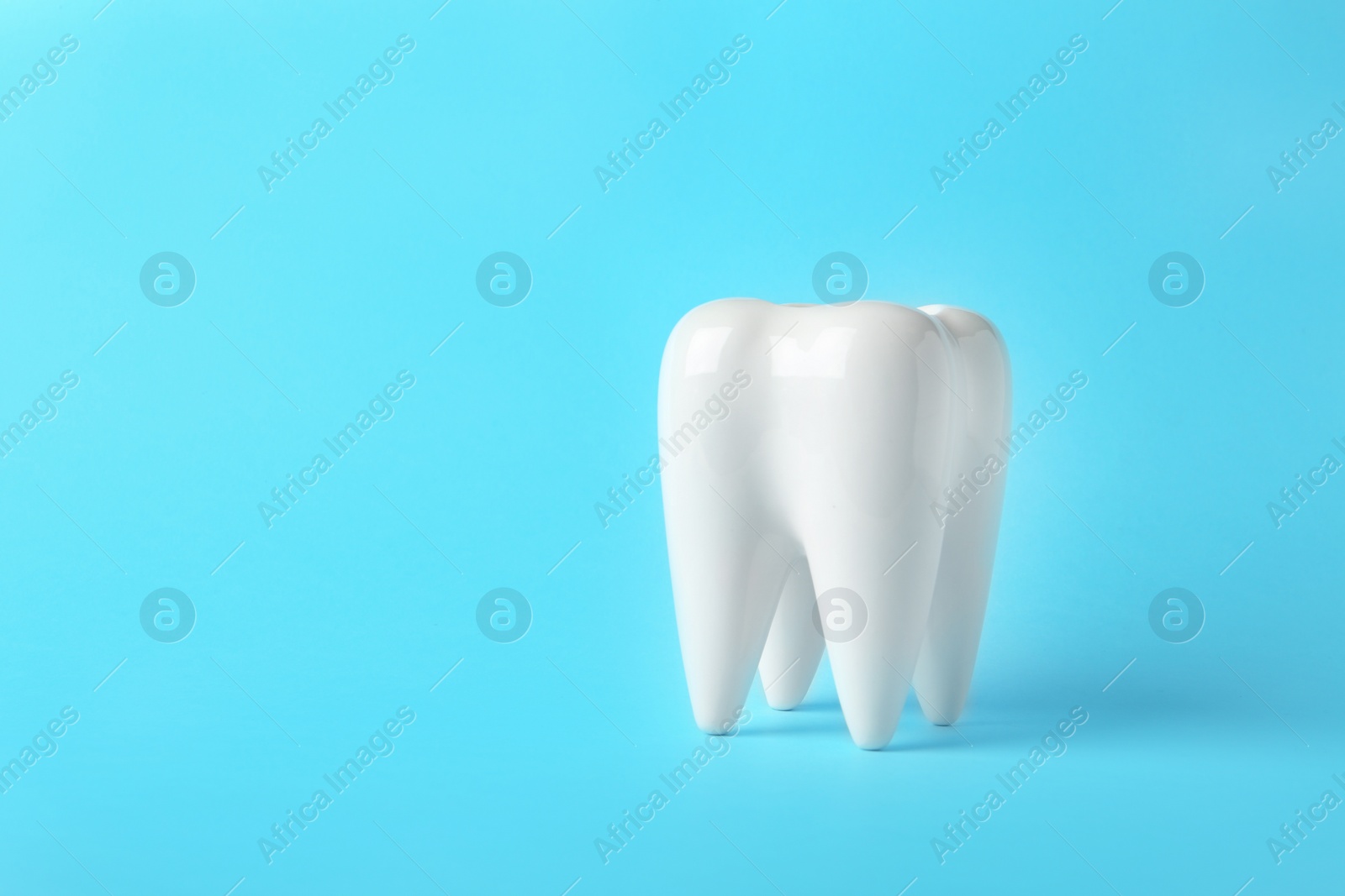 Photo of Ceramic model of tooth on color background. Space for text