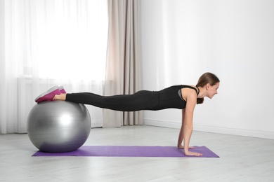 Photo of Young woman doing fitness exercises at home