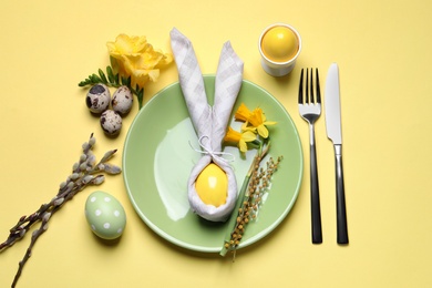 Photo of Festive Easter table setting with eggs on yellow background, flat lay