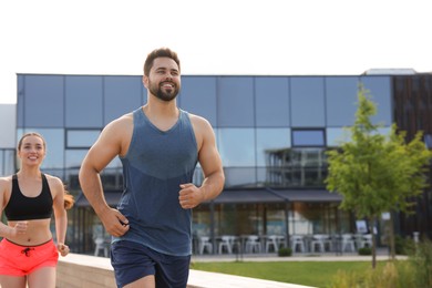 Photo of Healthy lifestyle. Happy couple running outdoors, space for text