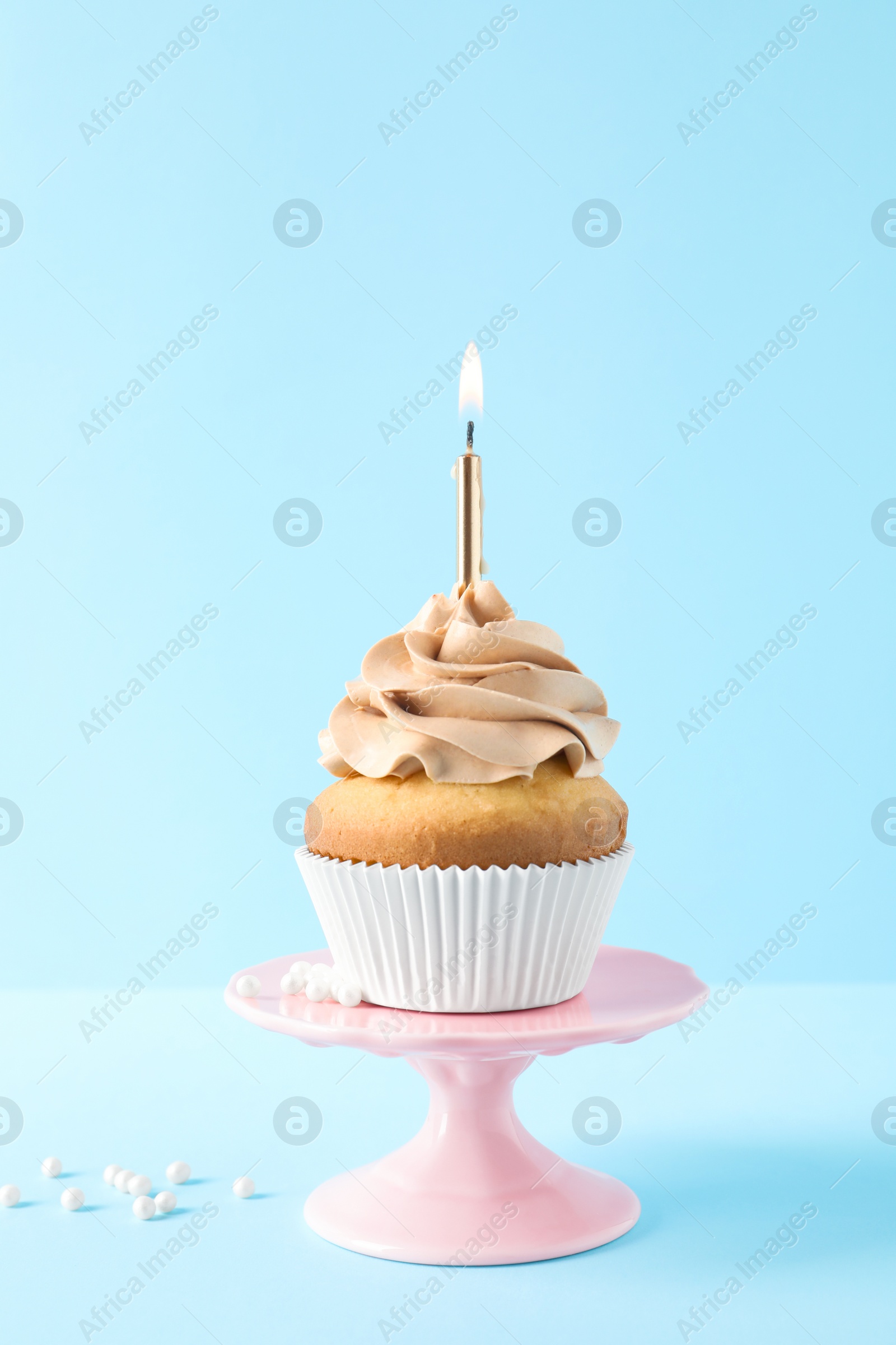 Photo of Dessert stand with delicious birthday cupcake on color background