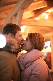 Cute couple in warm clothes at winter fair