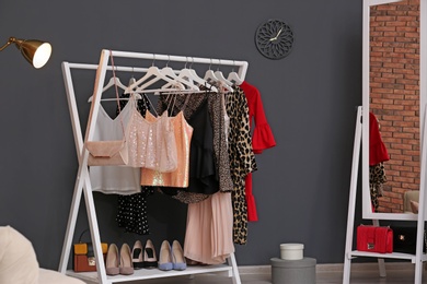 Wardrobe rack with women's clothes and shoes in dressing room