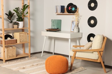 Photo of Room interior with stylish turntable on white table and vinyl records