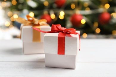 Photo of Beautiful gift boxes and blurred Christmas tree on background