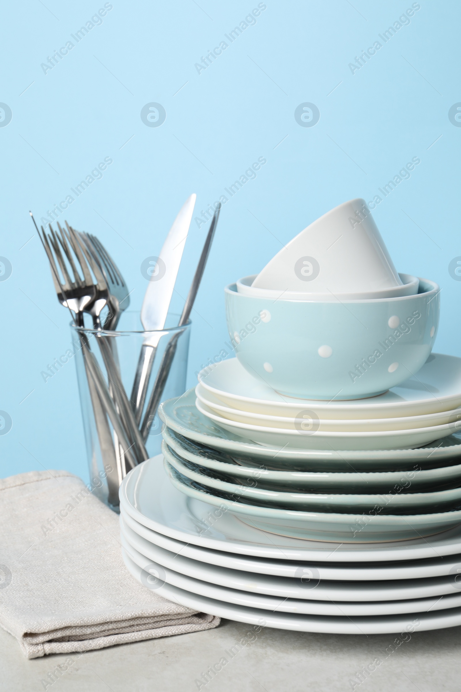 Photo of Beautiful ceramic dishware and cutlery on light grey table