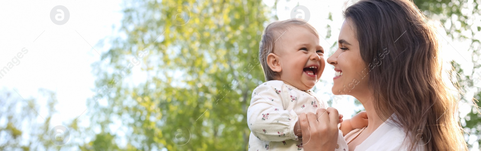 Image of Happy mother with her cute baby in park on sunny day, space for text. Banner design