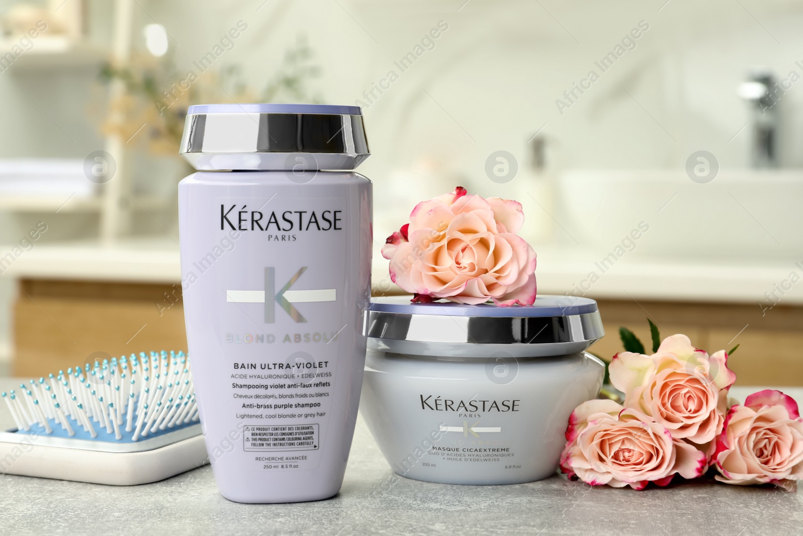 Photo of MYKOLAIV, UKRAINE - SEPTEMBER 07, 2021: Kerastase hair care cosmetic products and brush on light table in bathroom