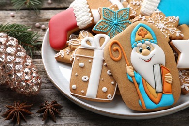 Photo of Tasty gingerbread cookies on wooden table, closeup. St. Nicholas Day celebration