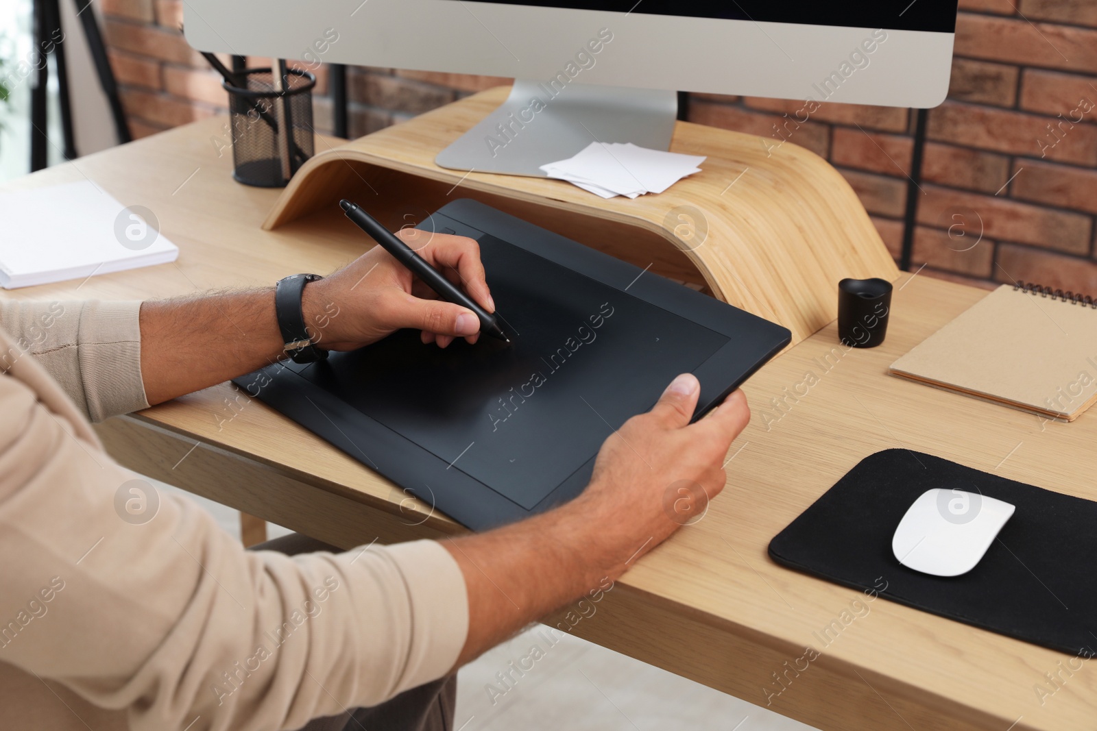 Photo of Professional retoucher working on graphic tablet at desk, closeup