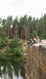 Young friends on rocky mountain near lake. Camping season
