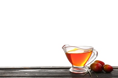 Photo of Palm oil and fruits on black wooden table against white background