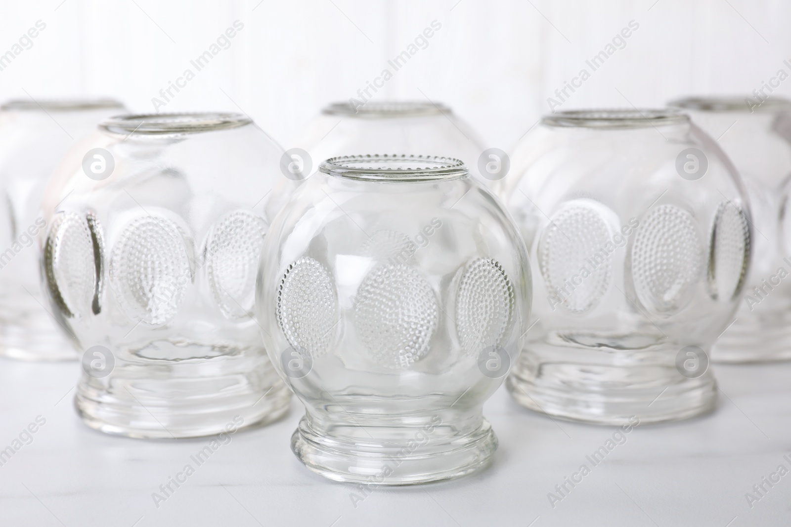 Photo of Glass cups on white table, closeup. Cupping therapy