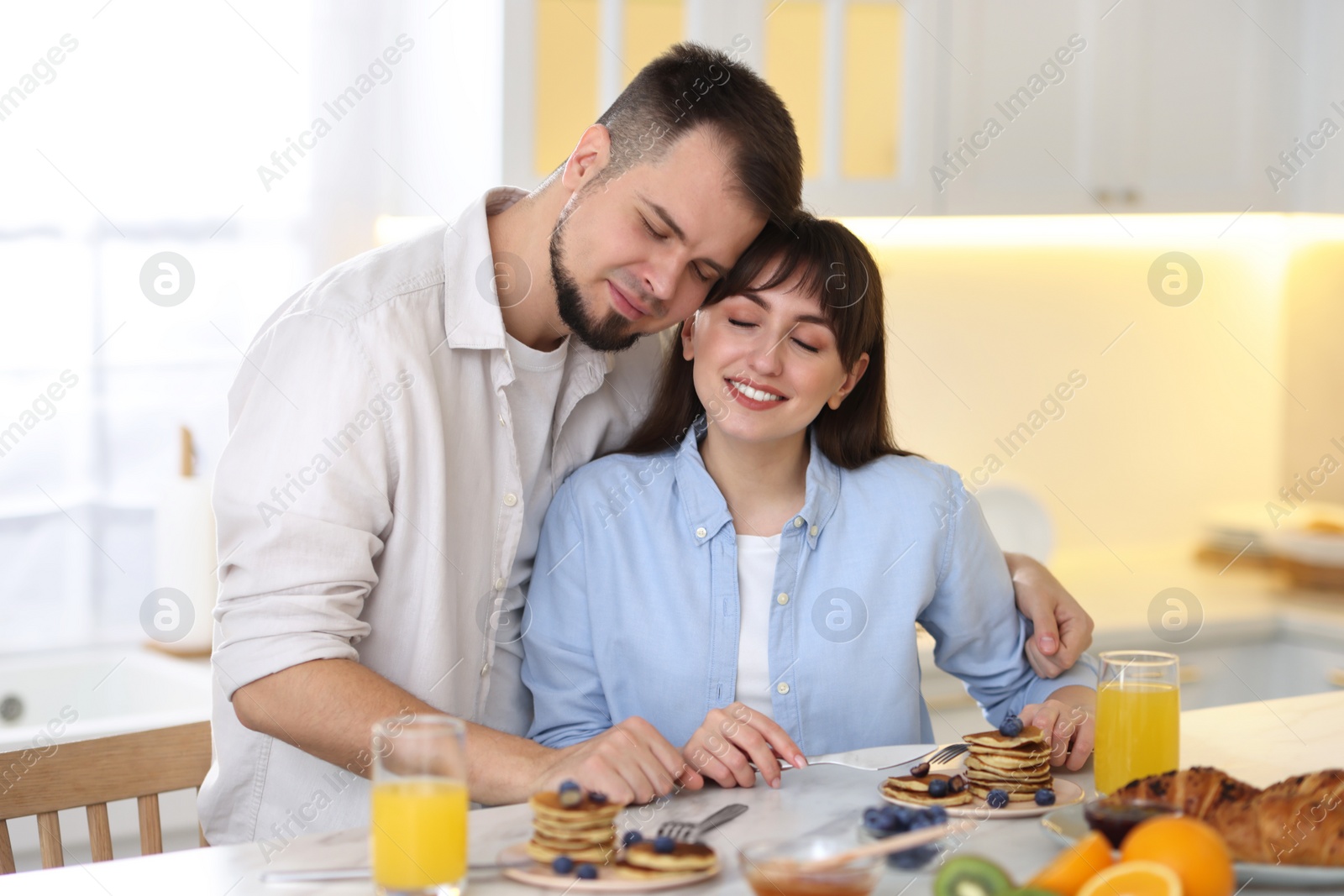 Photo of Happy couple spending time together during breakfast at home